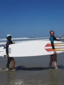 two women holding a surfboard
