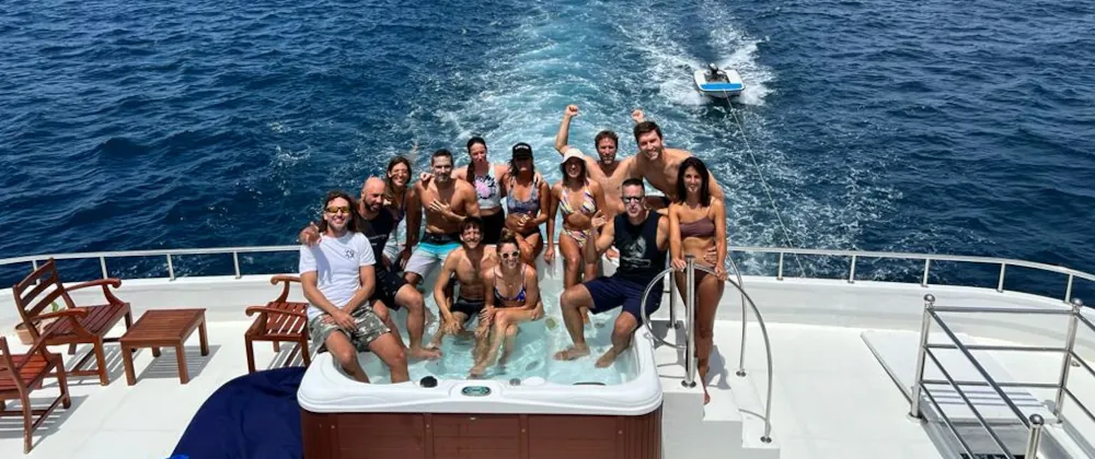 personnes posant pour une photo dans un bateau de luxe lors du Tour du monde de surf